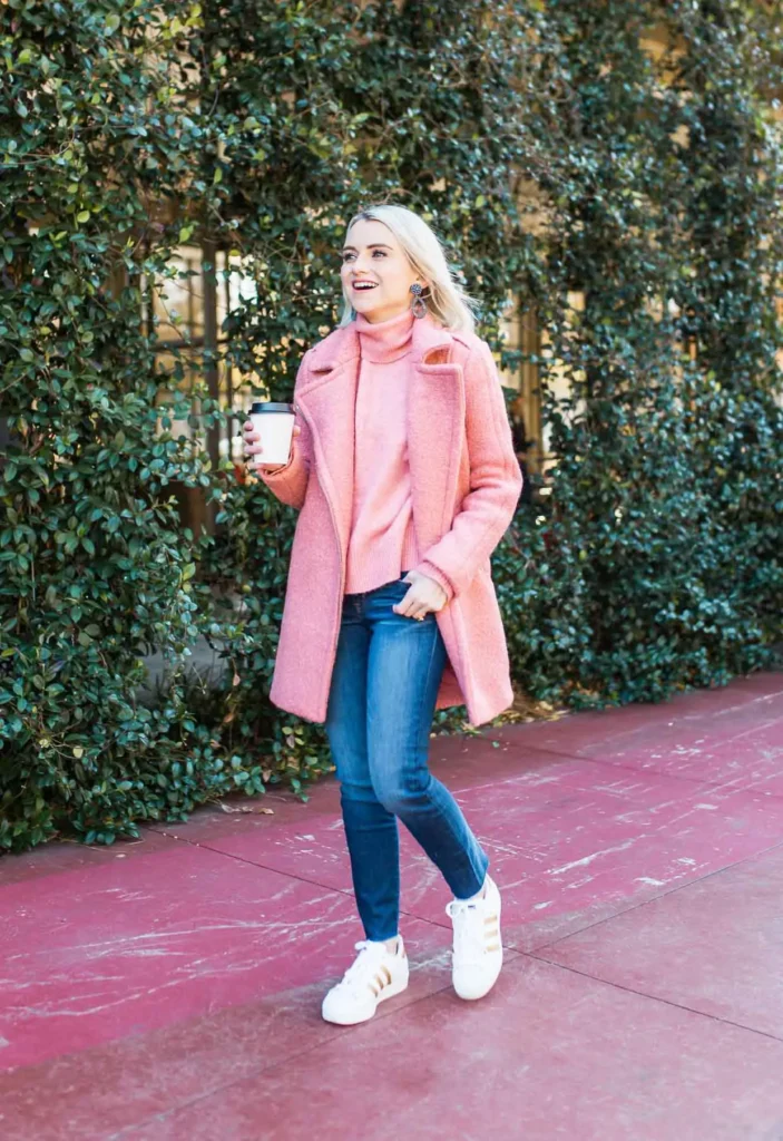 Pink Tonal Coat and Knit with Dark Skinny Jeans, petite woman in pink boucle coat and pink turtleneck, dark indigo skinny jeans and white sneakers with gold stripe outdoors.